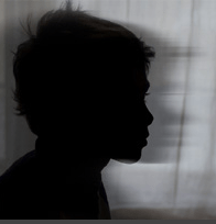a silhouette of a young boy and his shadow